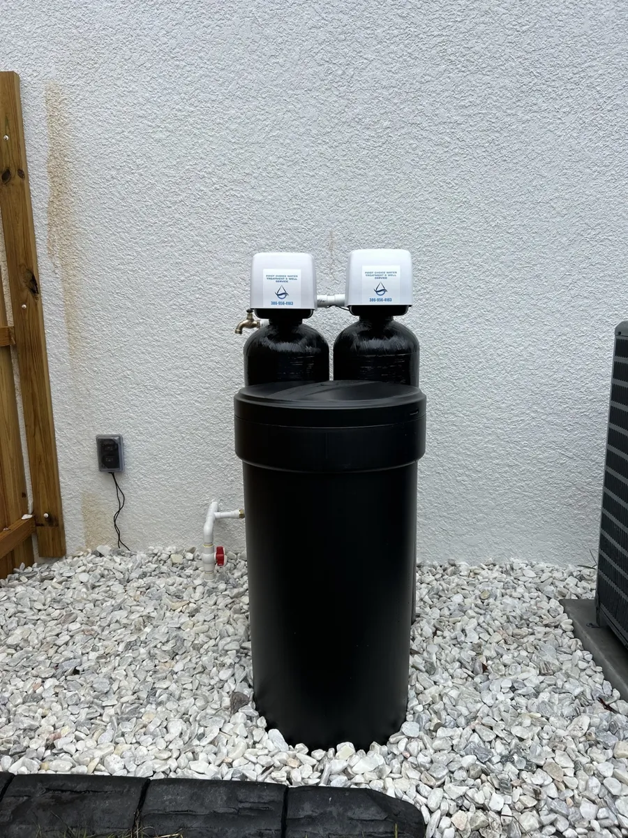 Black twin-tank system with brine tank installed on white gravel