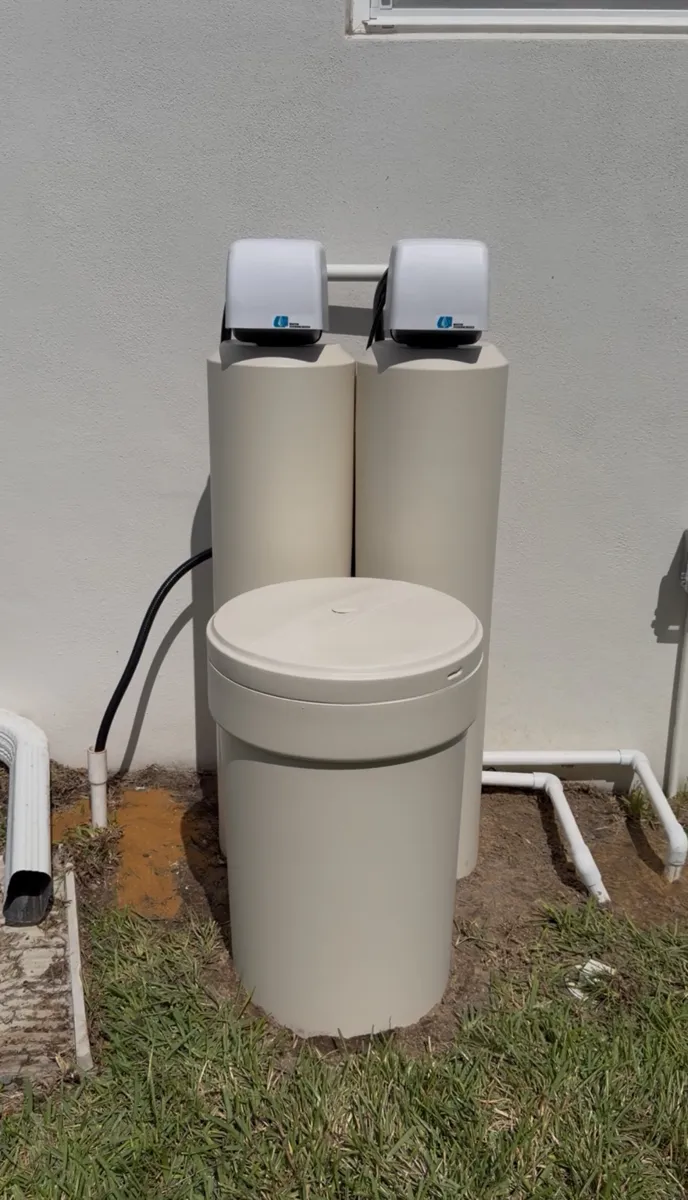 Twin-tank water treatment system with brine tank installed outside a Florida home