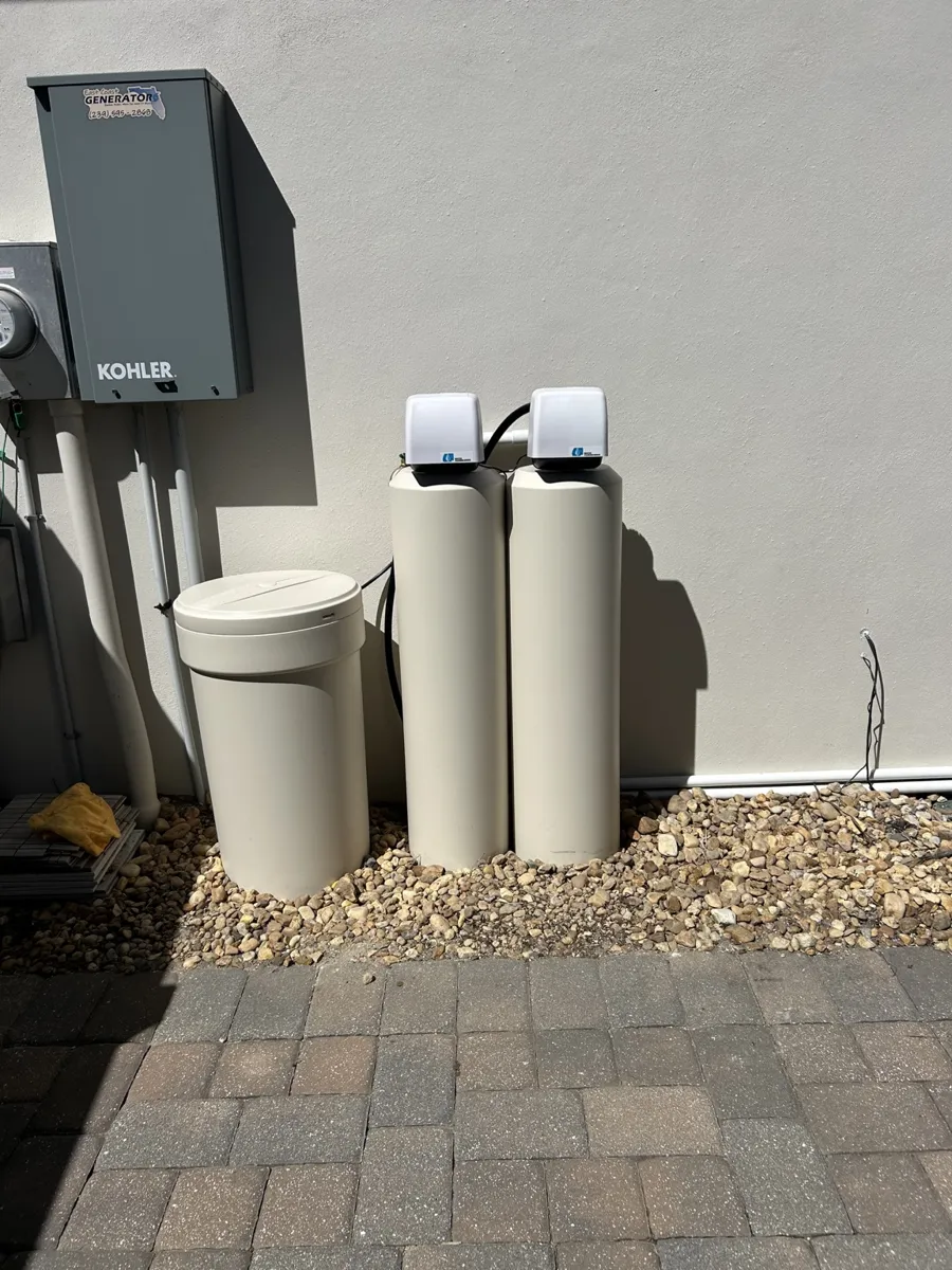 Twin-tank system and brine tank installed beside a home on gravel